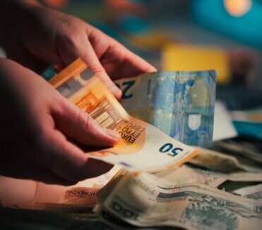 counting euro banknotes in dim lighting